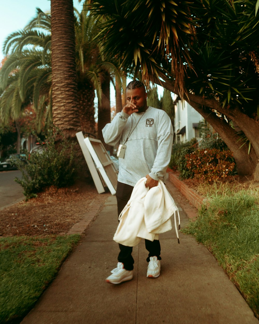 a man standing on a sidewalk talking on a cell phone