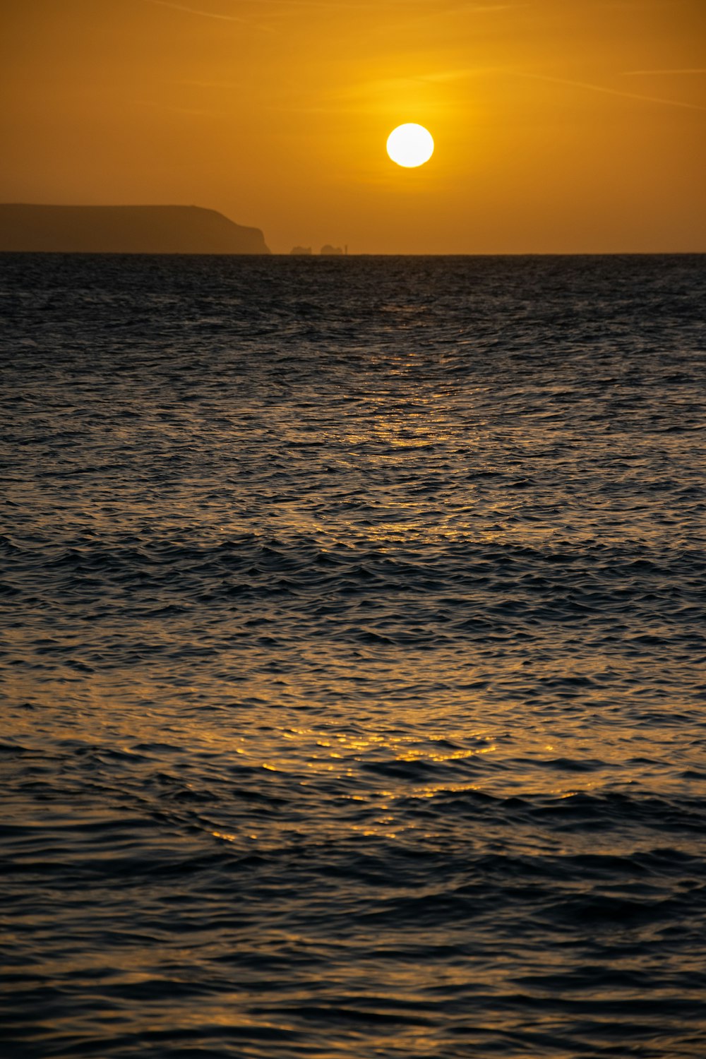 un grand plan d’eau avec un coucher de soleil en arrière-plan