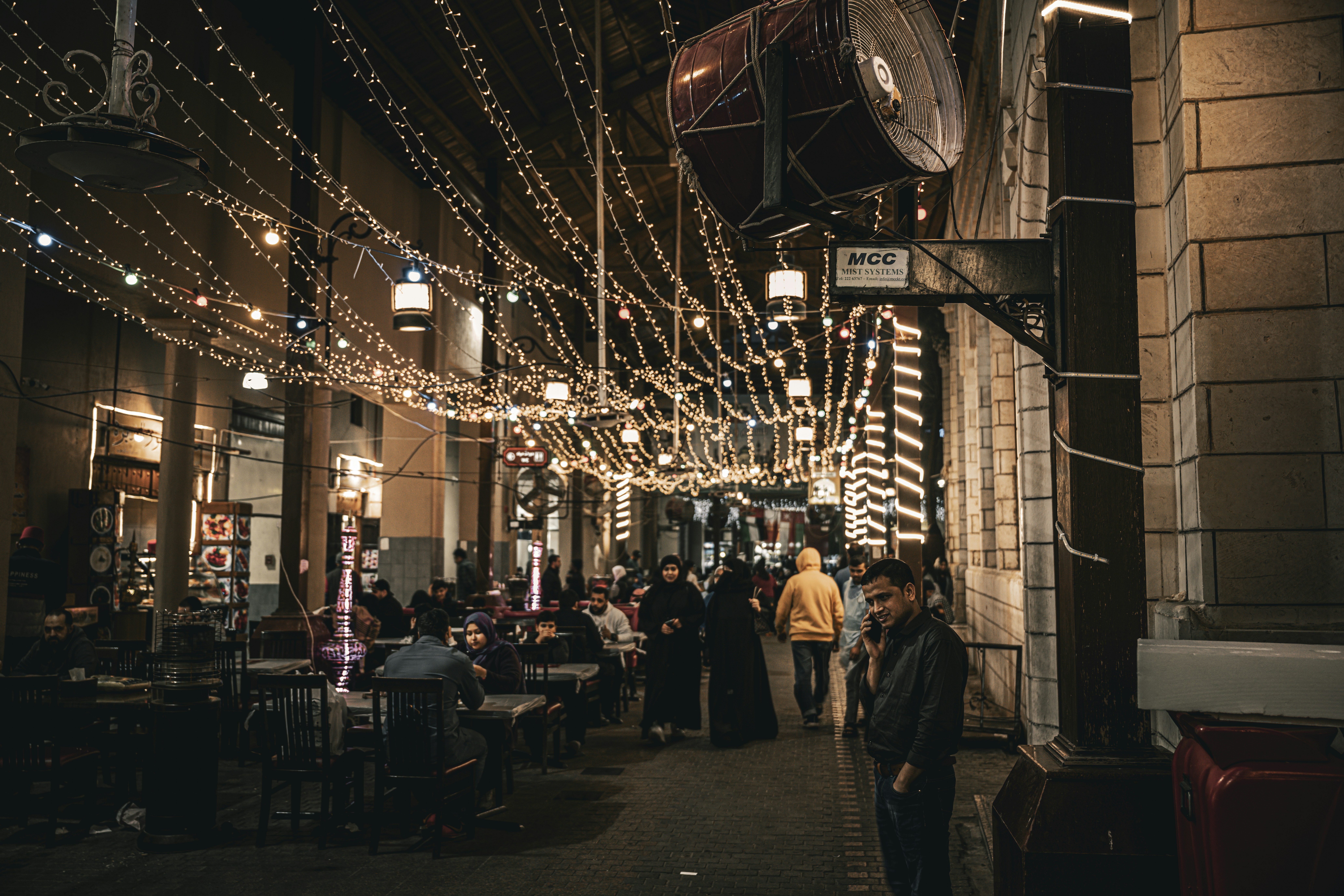 a group of people walking down a street at night