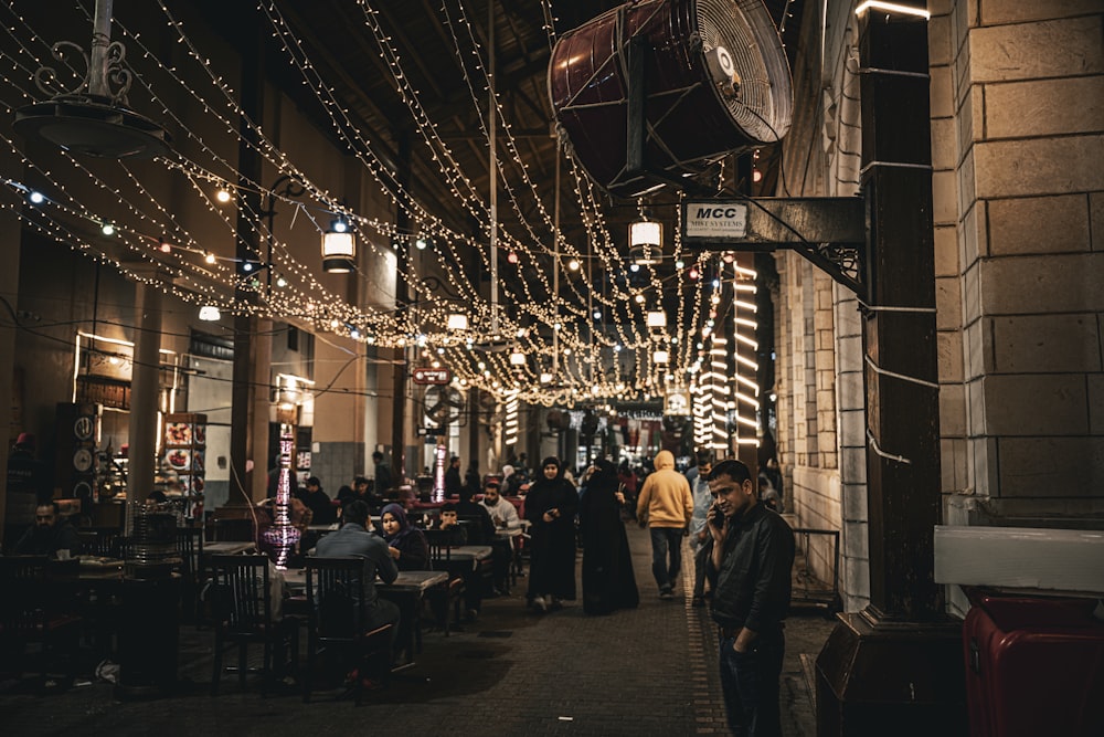 a group of people walking down a street at night