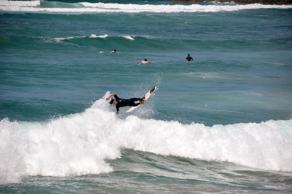 a man riding a wave on top of a surfboard