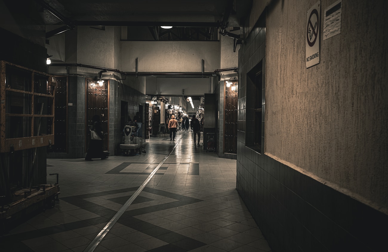People walking through an urban hallway with dramatic lighting
