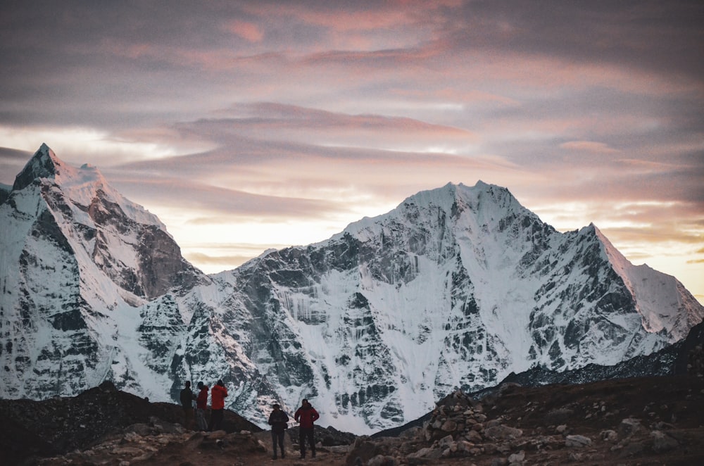 a group of people standing on top of a snow covered mountain