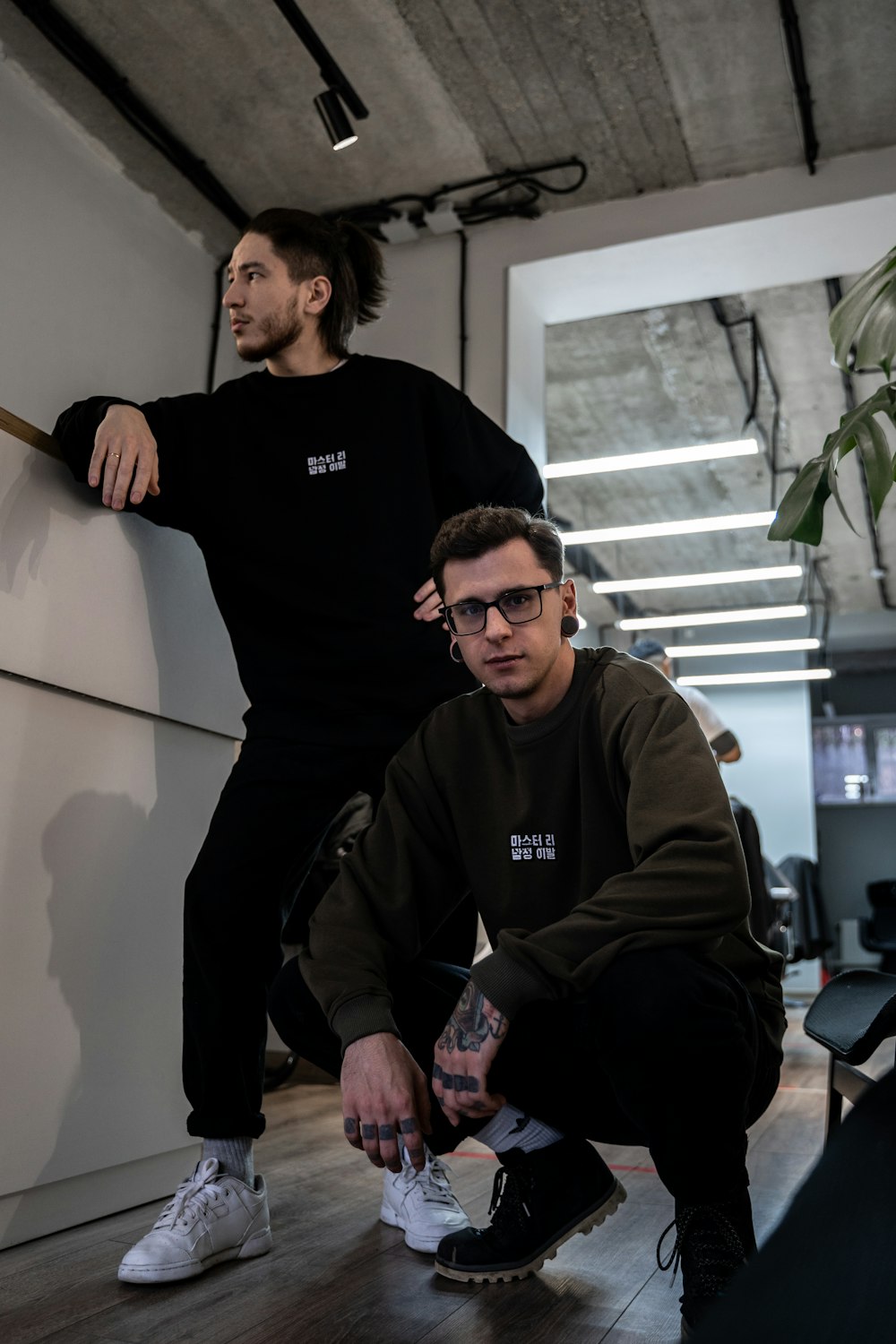 two men sitting on a wall in a room