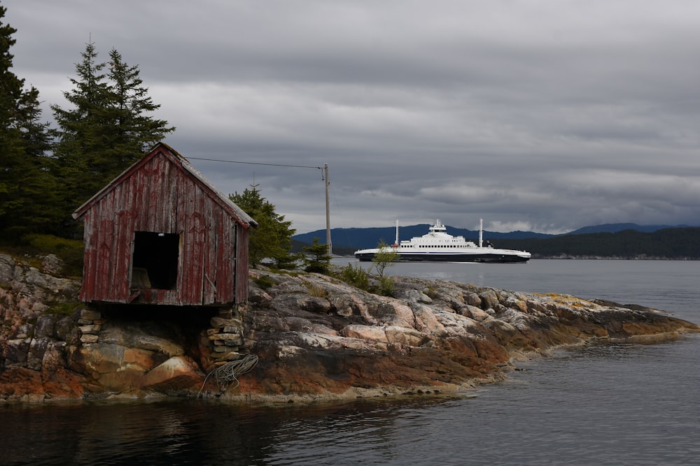 a boat is in the water near a small house