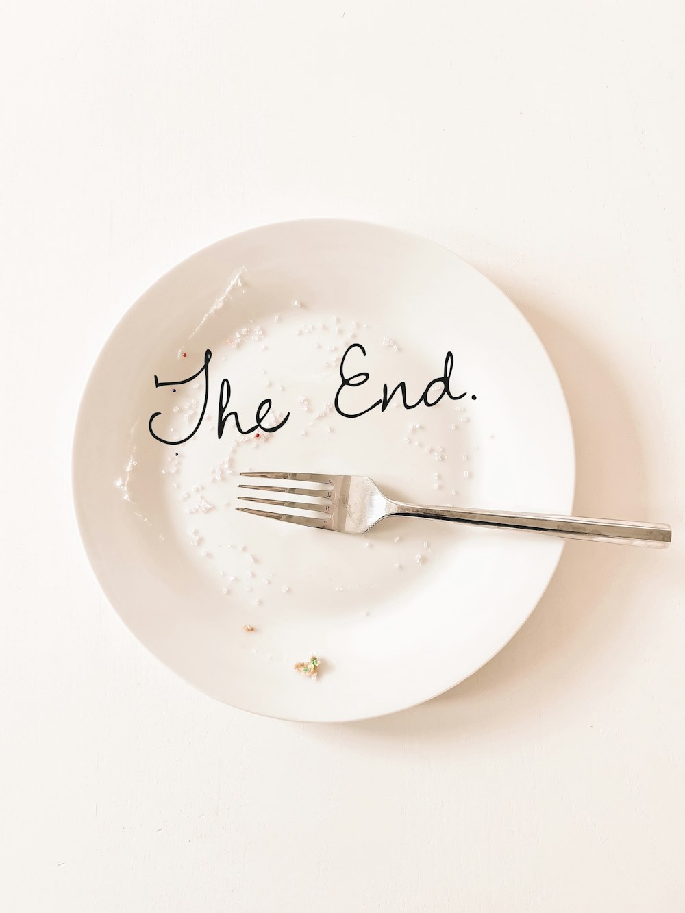 a white plate with a fork and the end written on it