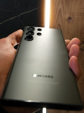 A sleek Samsung Galaxy smartphone displayed on a wooden table with natural light.