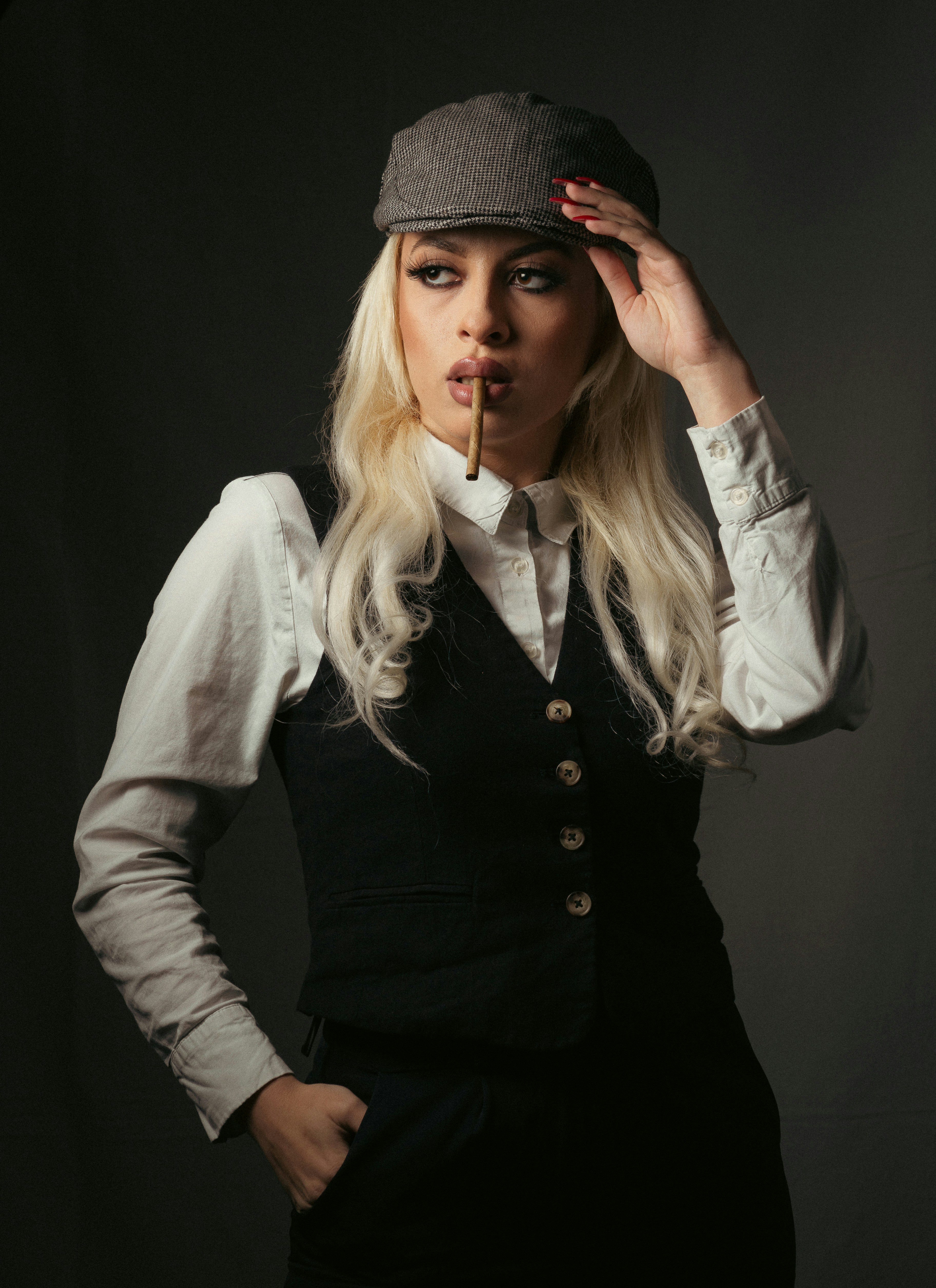 a woman with a hat and a cigarette in her mouth
