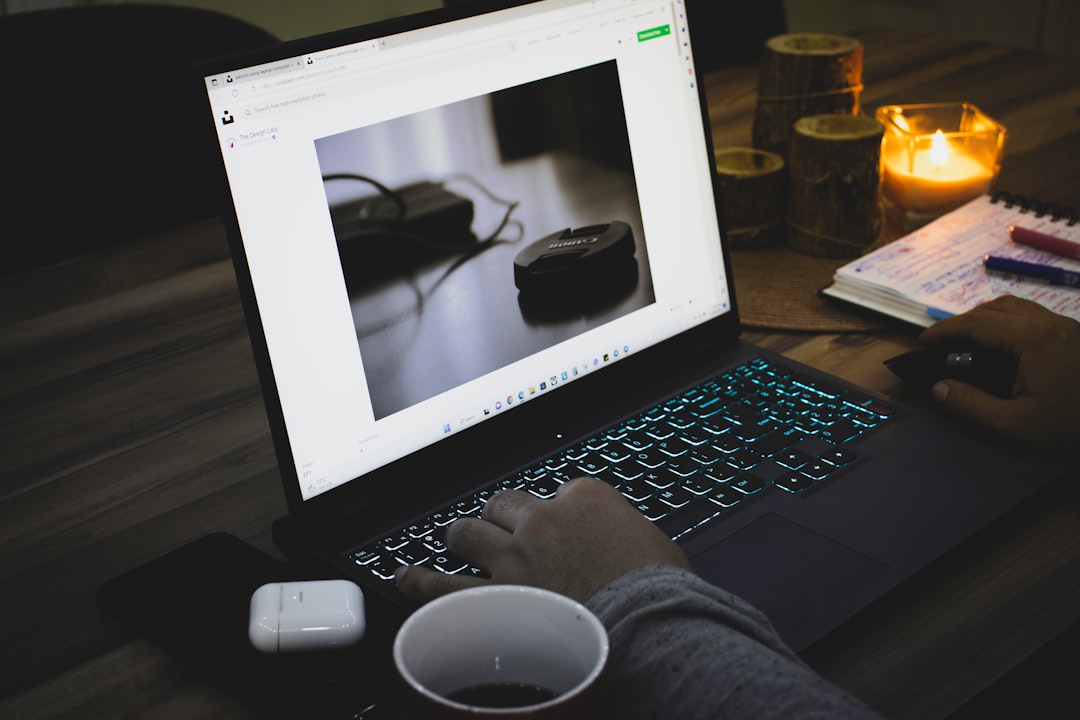 A macOS laptop showing a browser at night, the screen glowing in a dark room