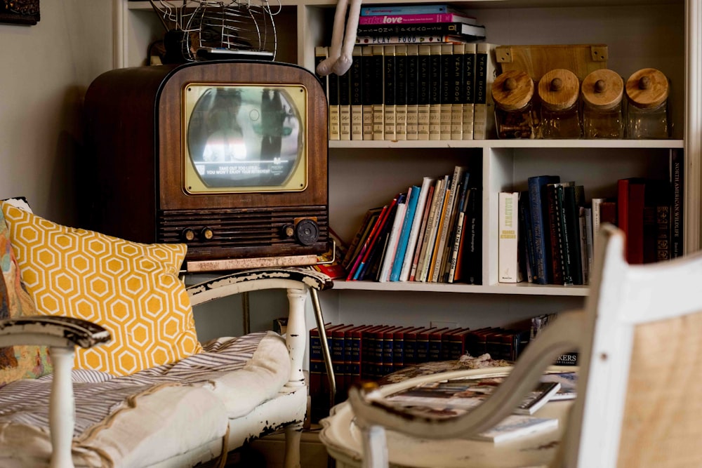 an old tv sitting on top of a book shelf