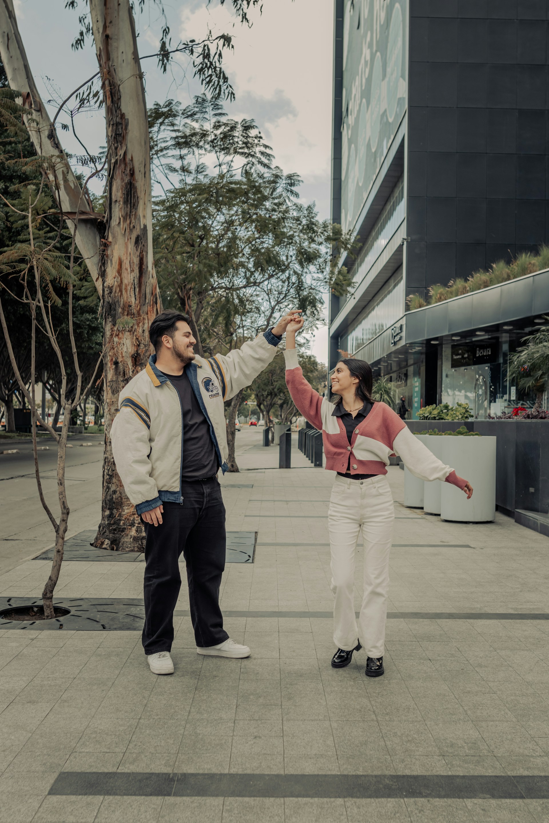 a man standing next to a woman on a sidewalk