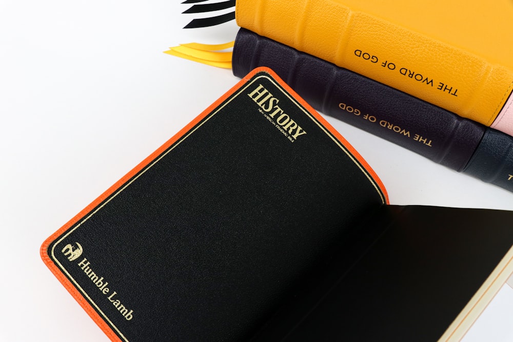 a black and orange book sitting on top of a white table