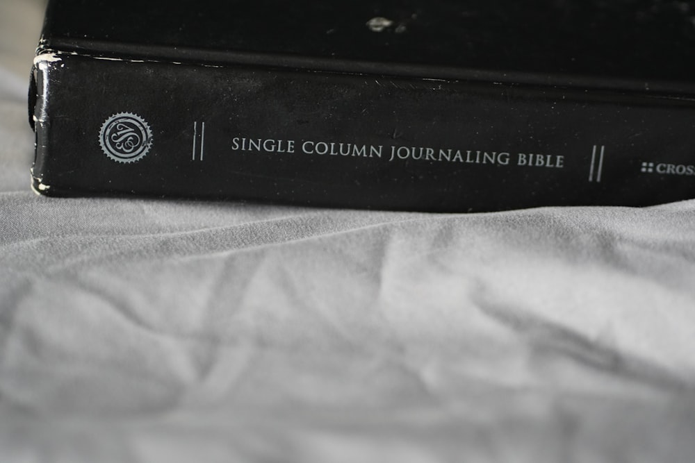 a black book sitting on top of a bed