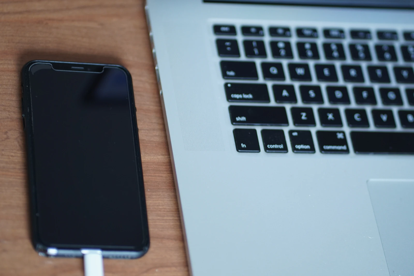iPhone conectado por cabo USB ao lado de notebook