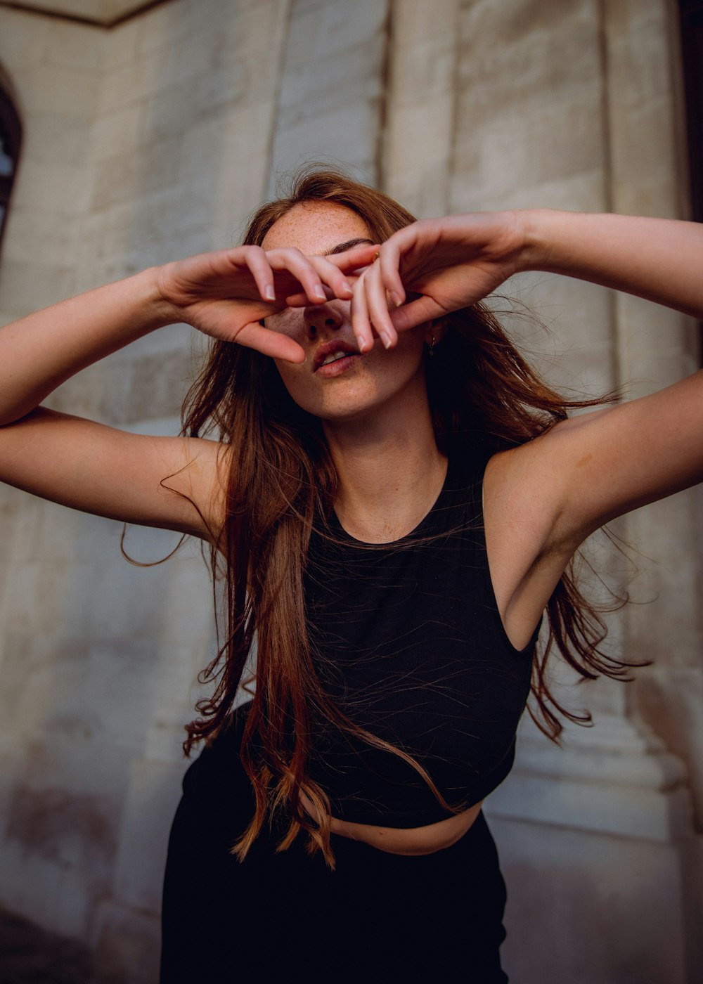 a woman is holding her hands to her face