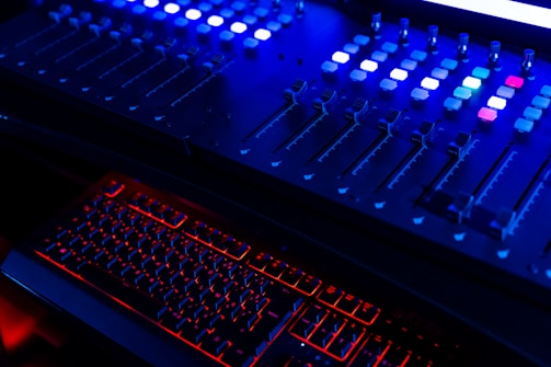Soundboard glowing with blue and orange lights in a dimly lit studio.