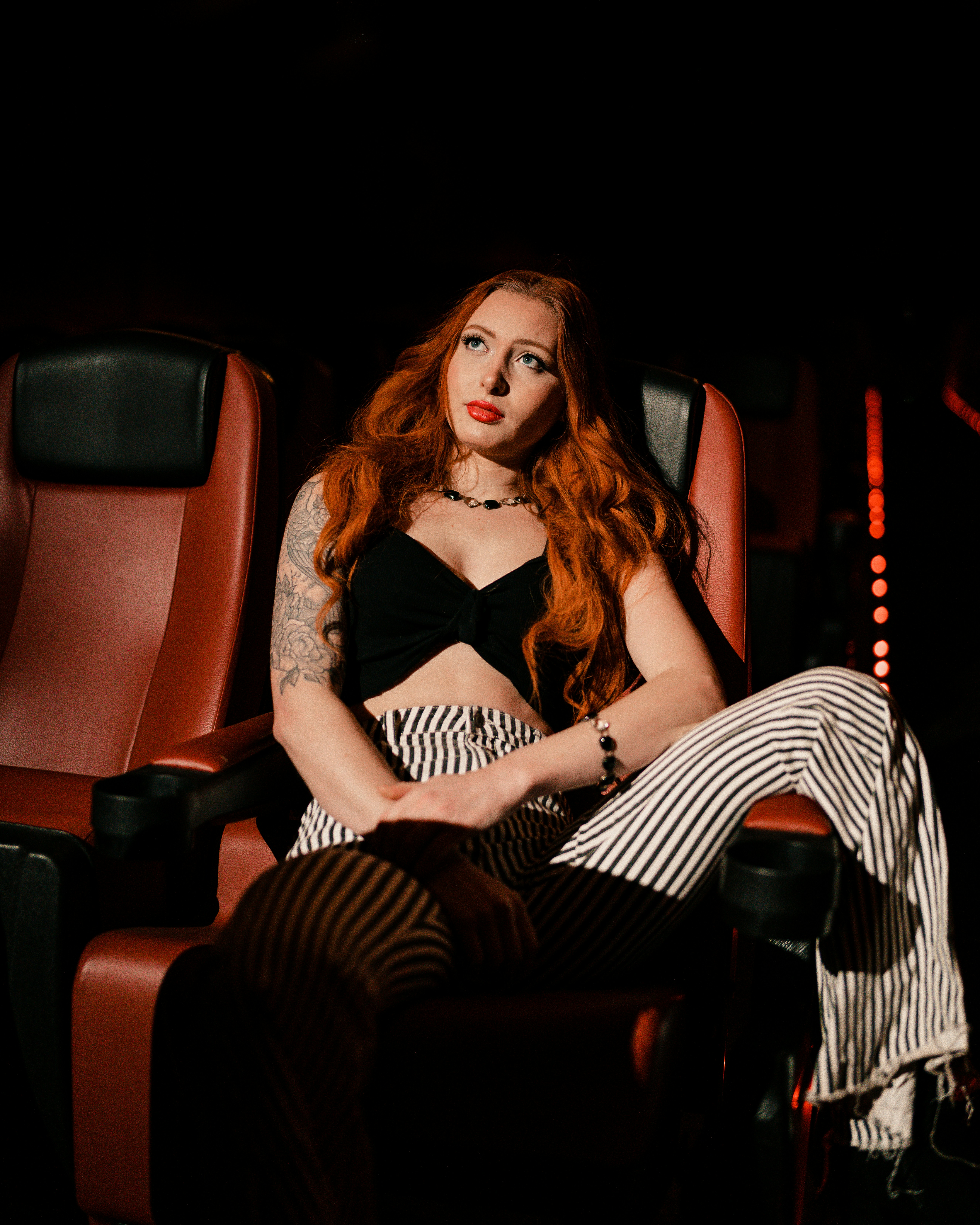 a woman with red hair sitting in a chair