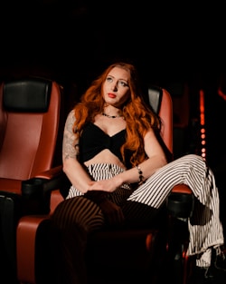 a woman with red hair sitting in a chair