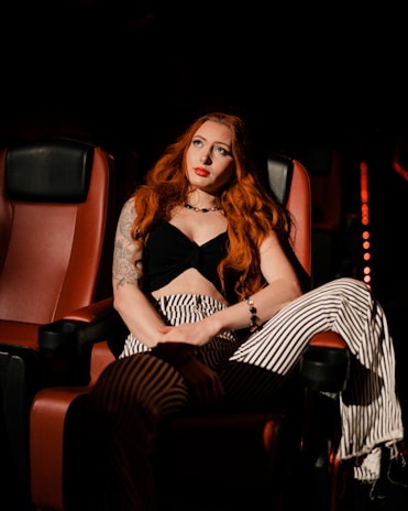 a woman with red hair sitting in a chair