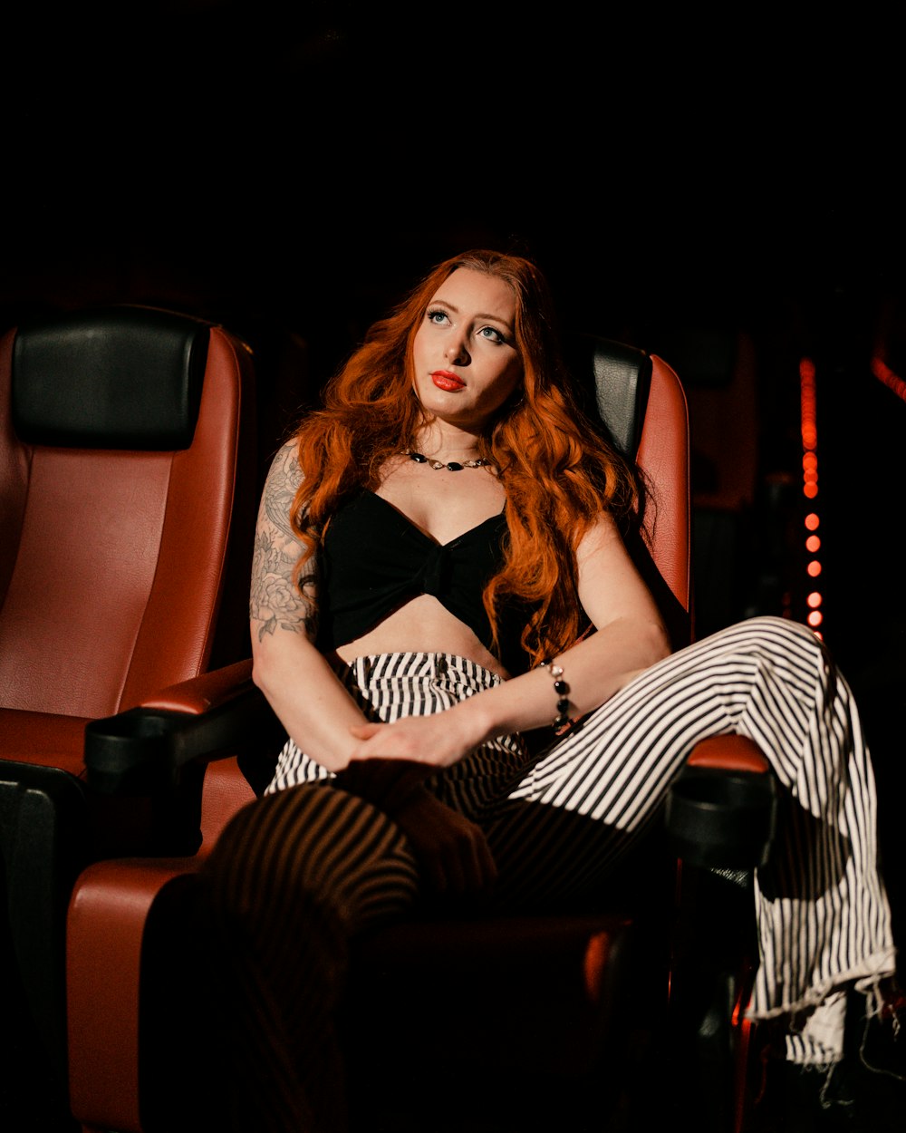 a woman with red hair sitting in a chair