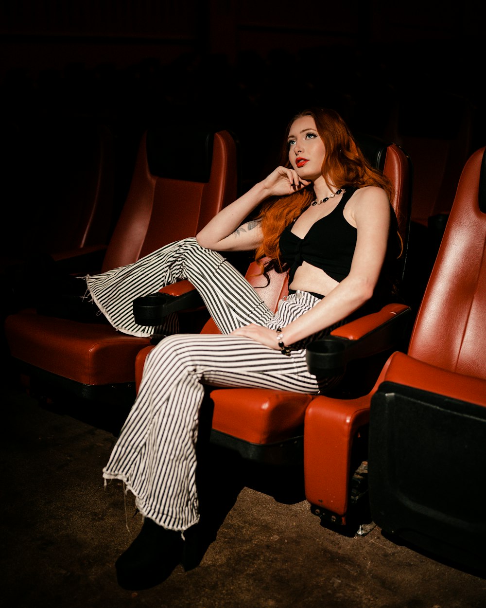a woman with red hair sitting on a red chair