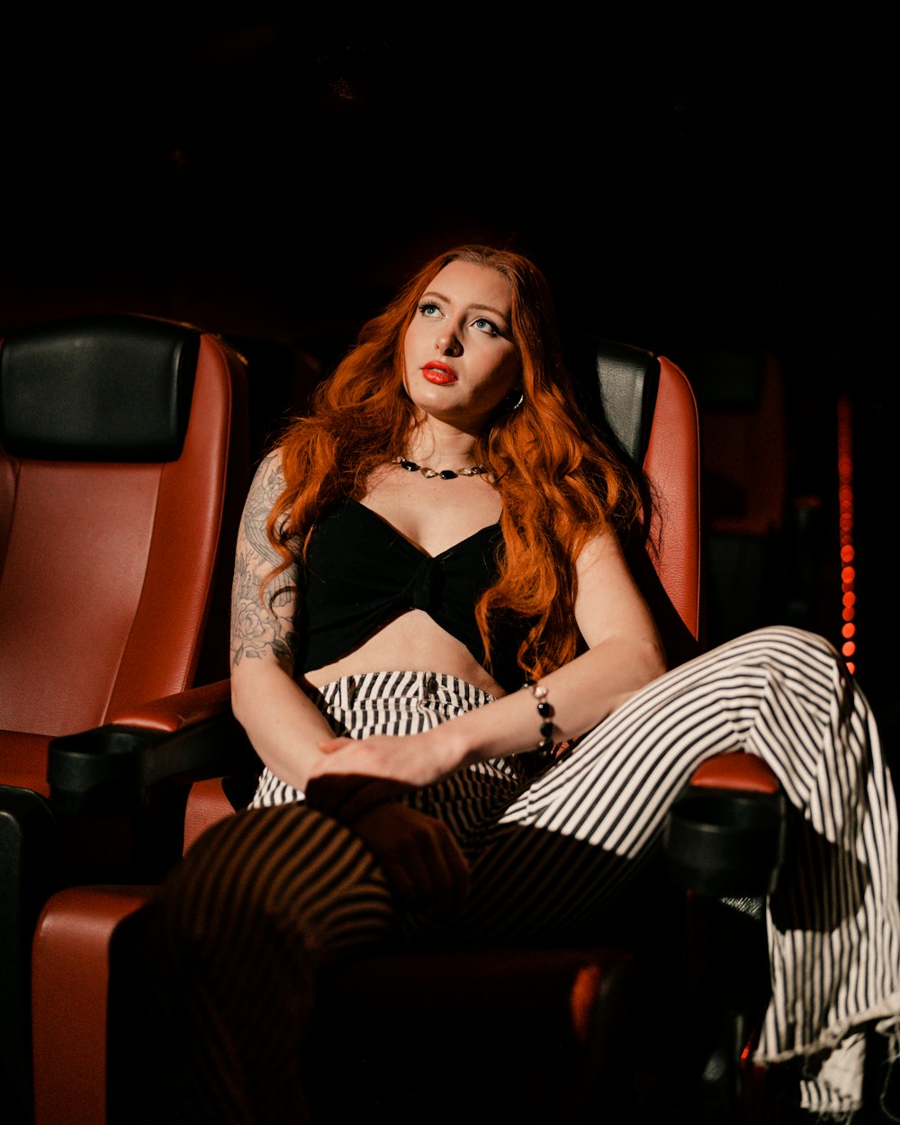 a woman with red hair sitting in a chair