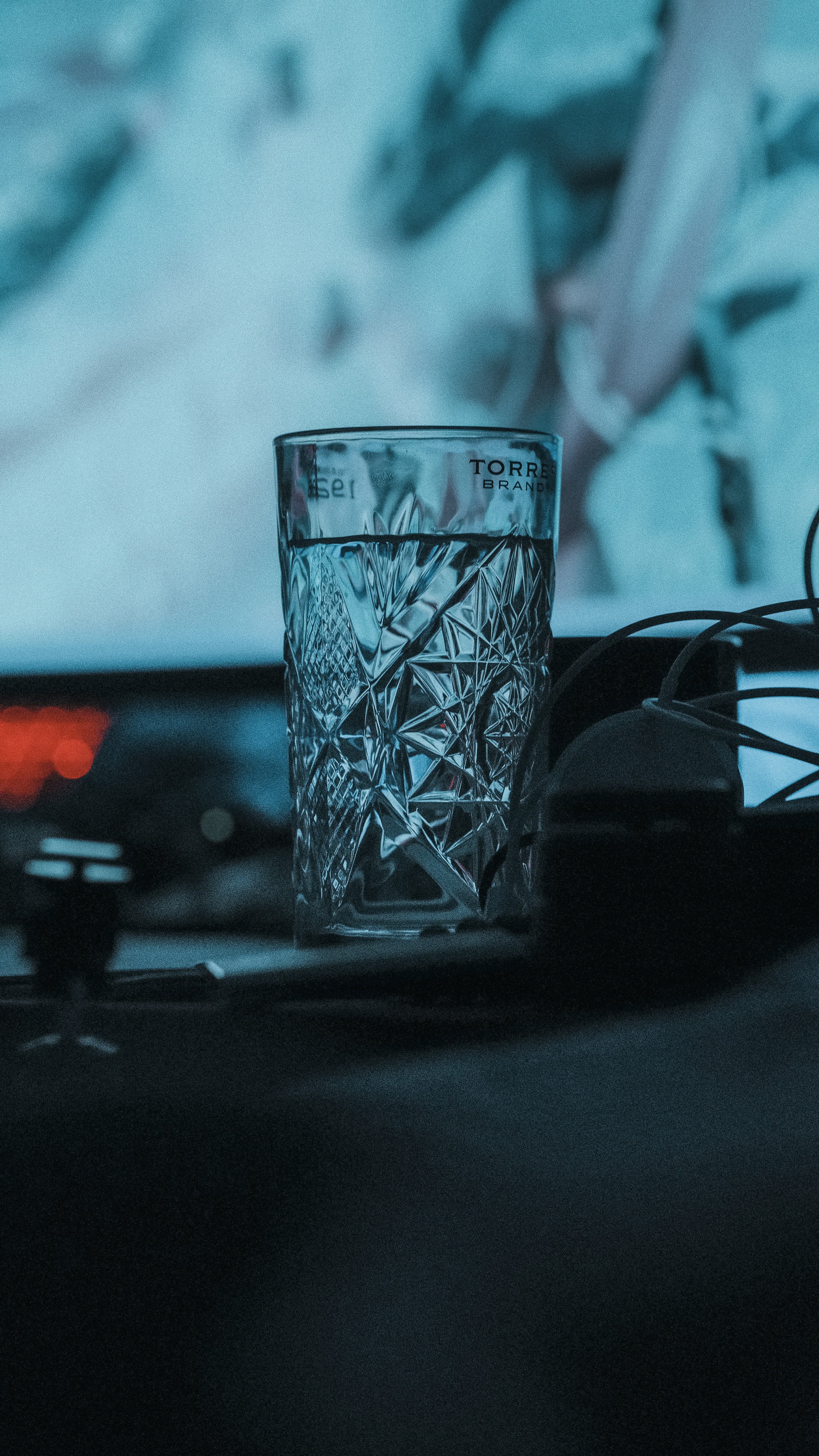 A glass of water sitting on top of a table photo – Free Dark Image on ...