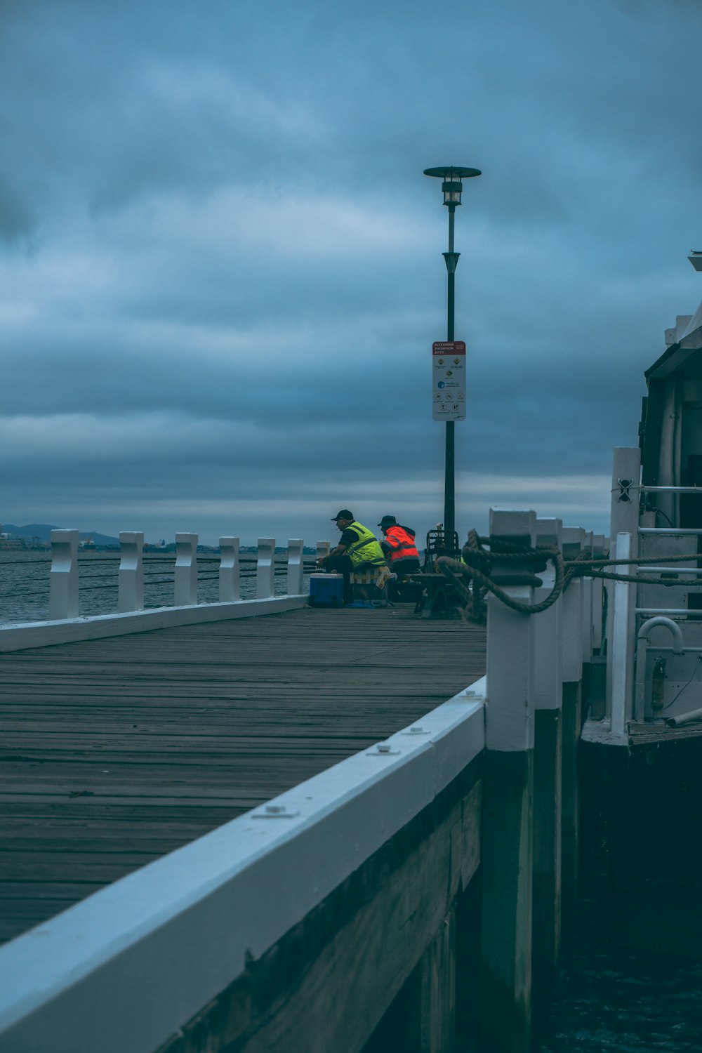 a couple of people that are sitting on a dock