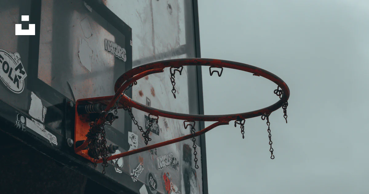 A basketball going through the rim of a basketball hoop photo – Free ...