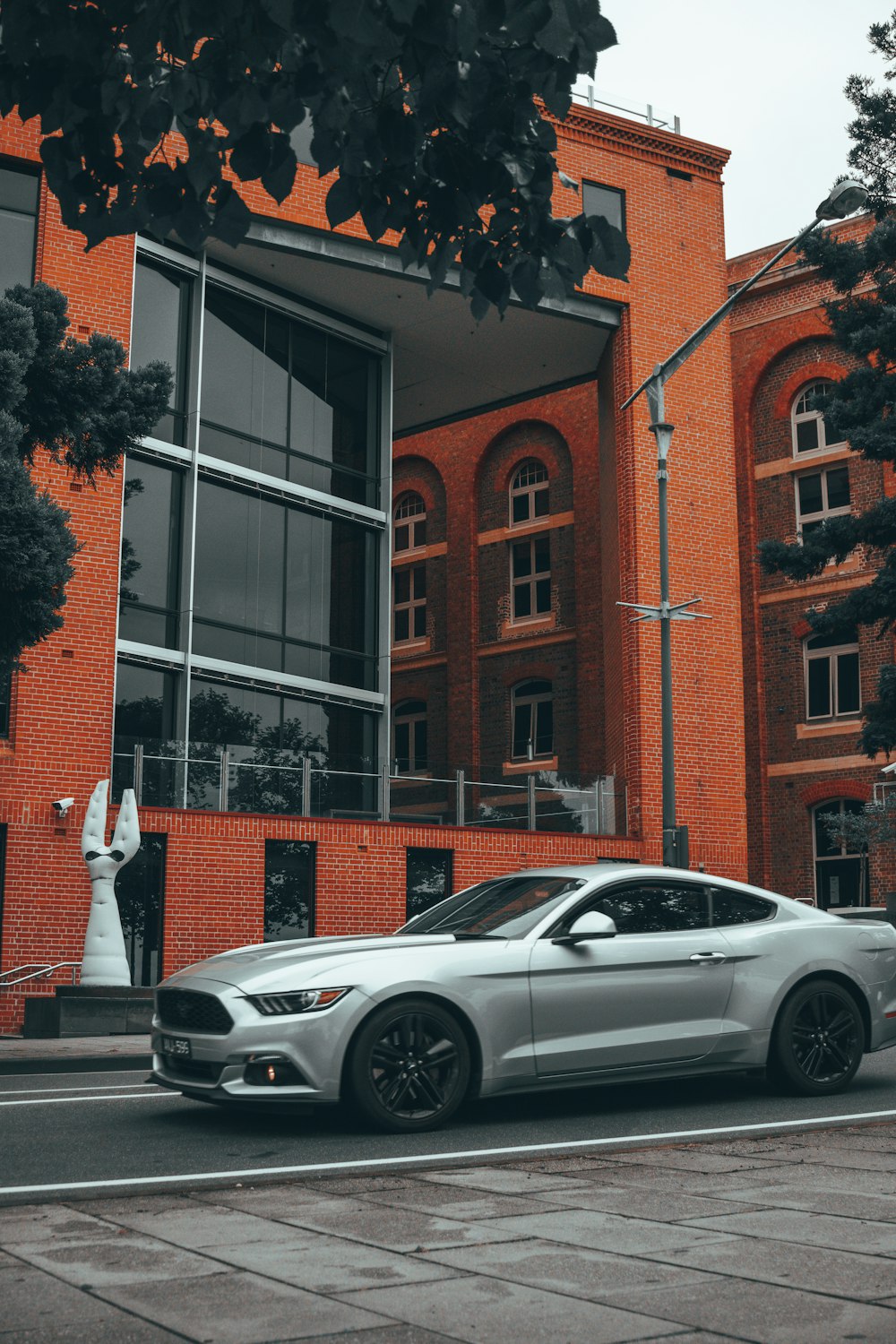 a silver car parked in front of a red brick building