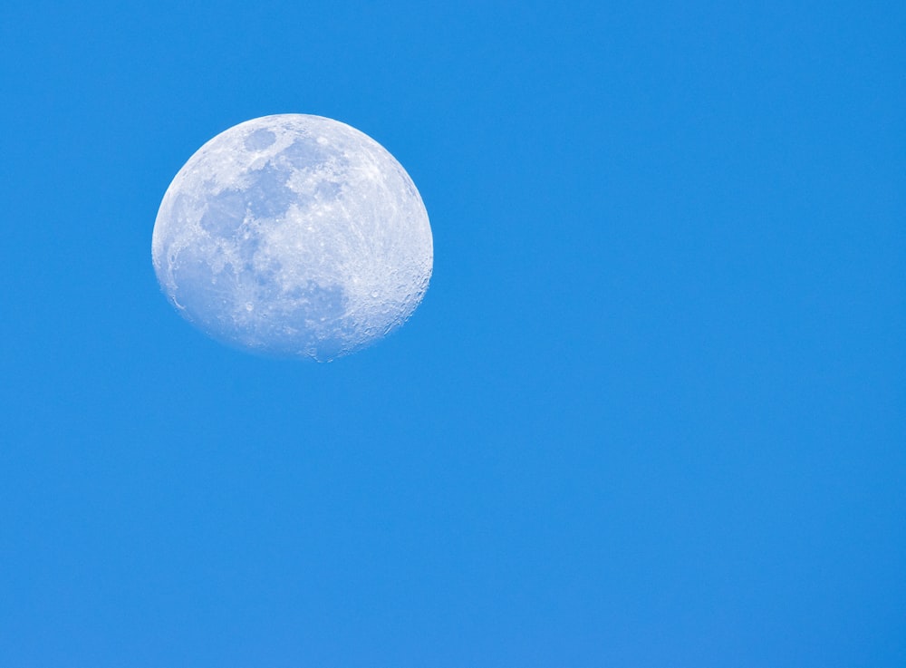 a full moon in a clear blue sky