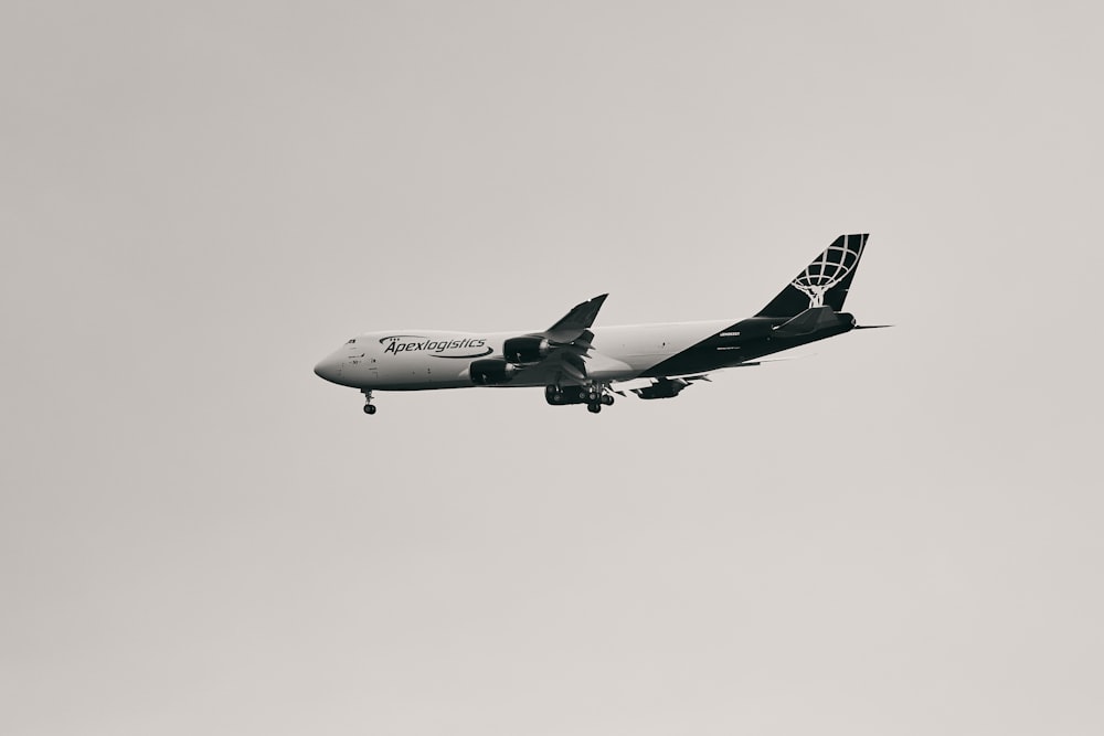 a large jetliner flying through a gray sky