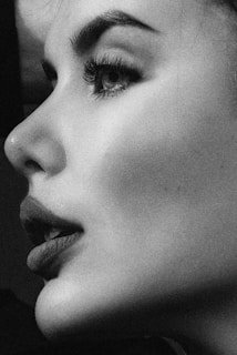 Film grain texture overlay on a dark feminine portrait in low light.