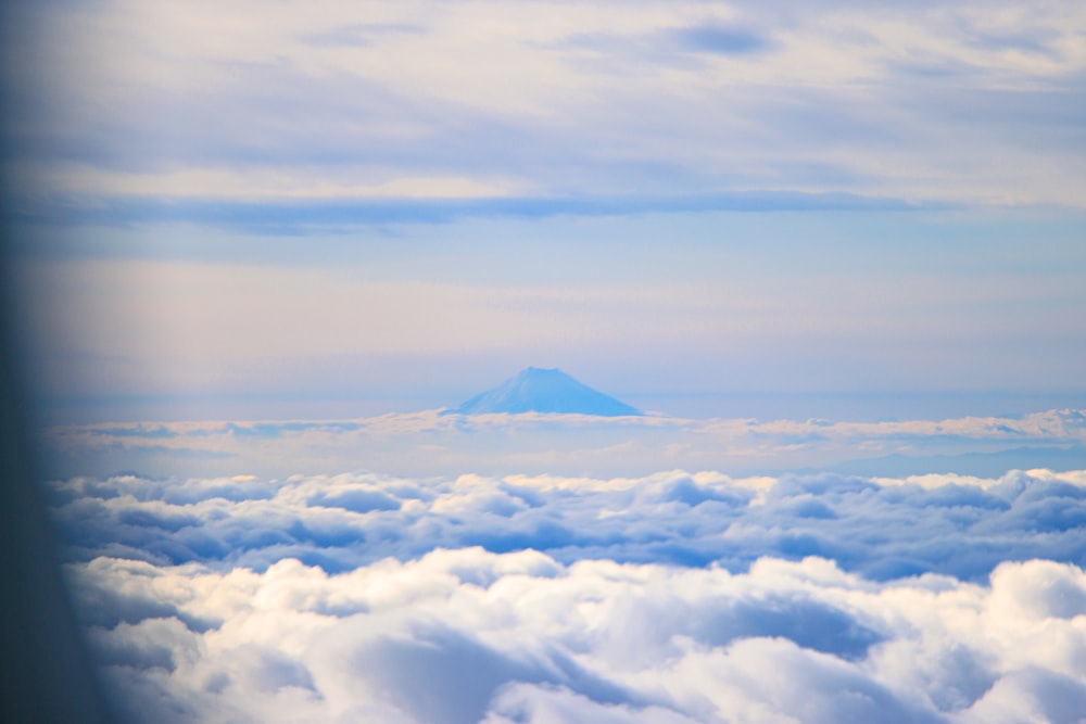 a view of a mountain in the distance above the clouds