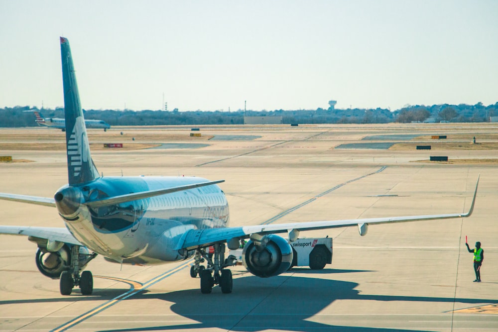 a blue and white airplane is on the runway