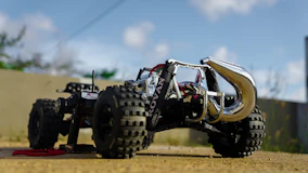 a toy truck with four wheels on a dirt road