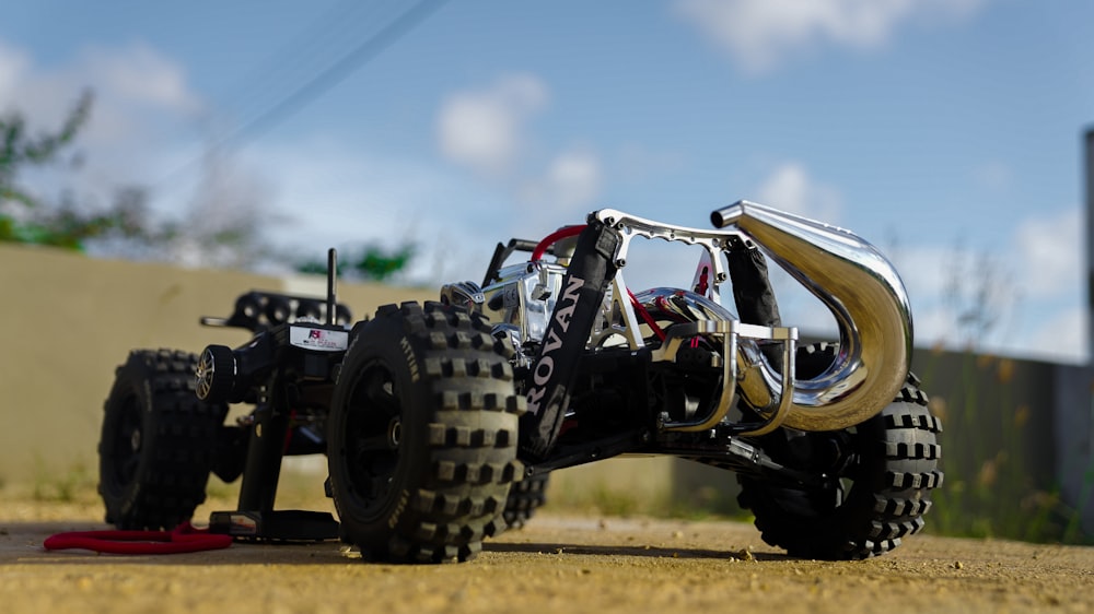 a toy truck with four wheels on a dirt road