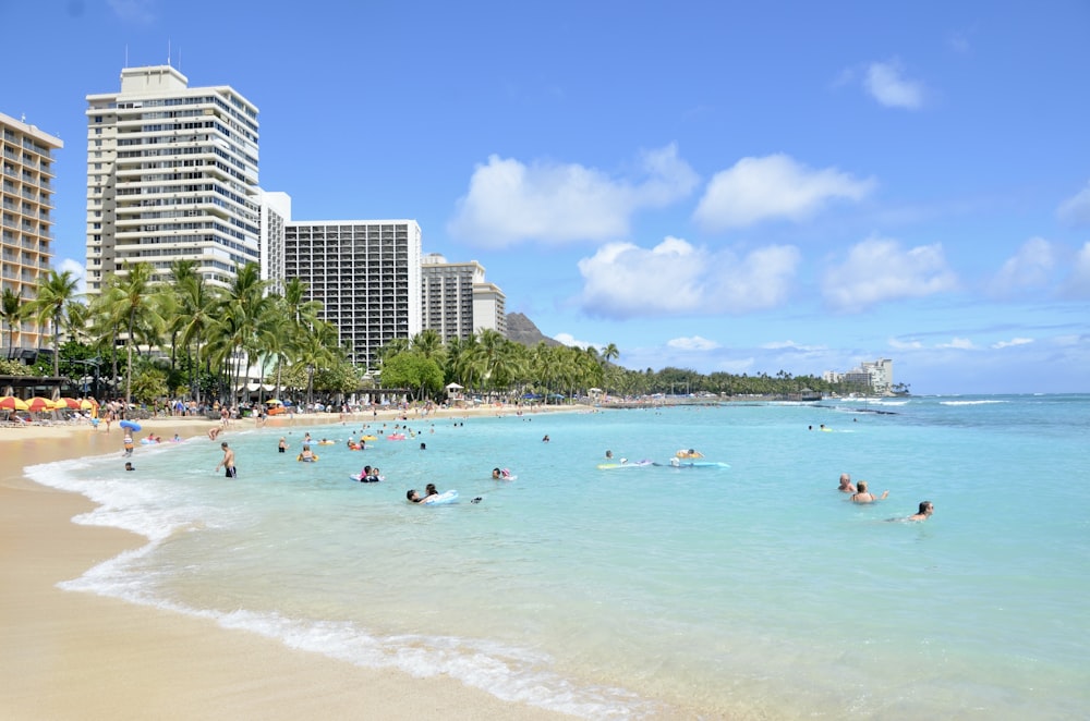 a beach with people swimming in the water