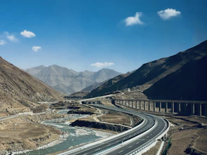 An aerial view of a newly built highway cutting through a mountainous landscape.