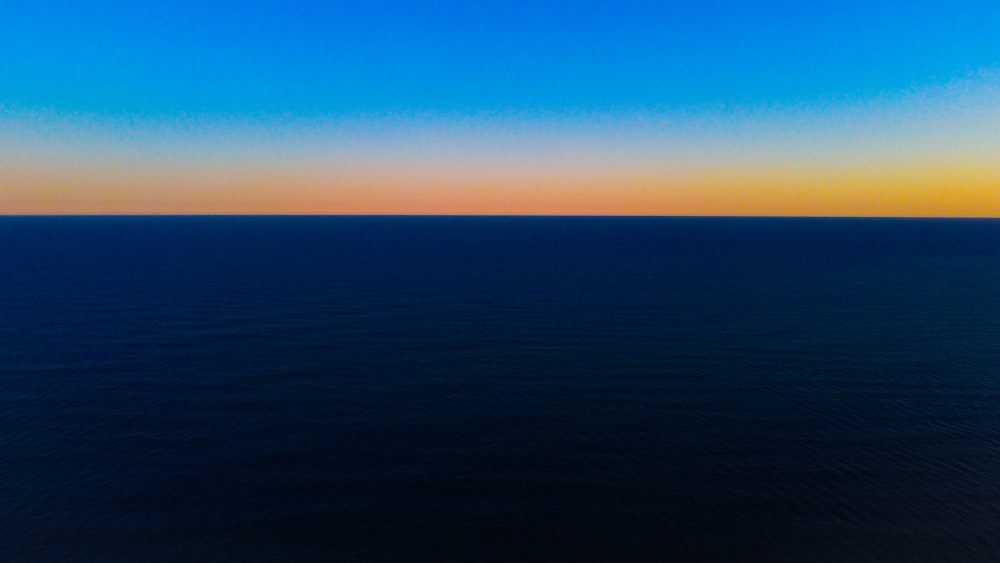 a large body of water sitting under a blue sky