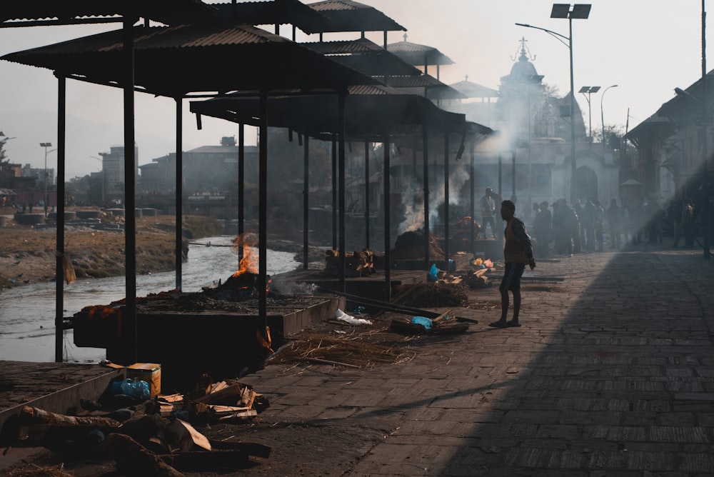 a man walking down a street next to a river