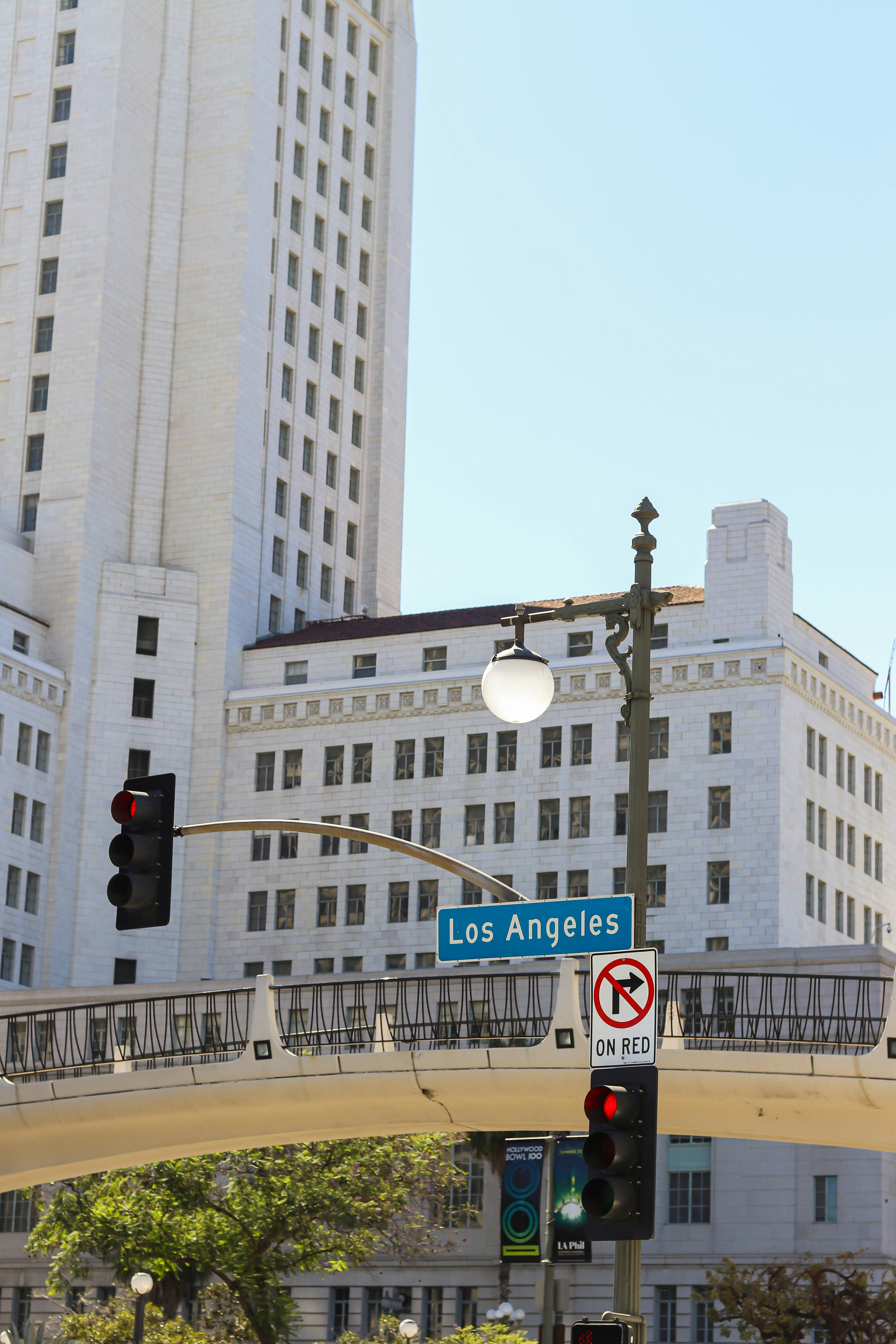 un semáforo y una señal de tráfico frente a un gran edificio blanco