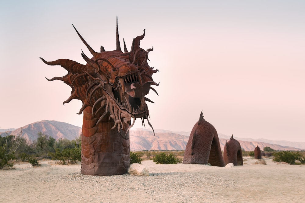 a sculpture of a dragon in the middle of a desert