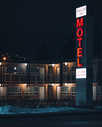 a motel sign lit up at night in front of a motel