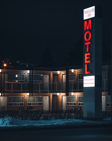 a motel sign lit up at night in front of a motel