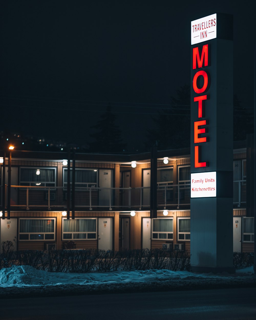 a motel sign lit up at night in front of a motel