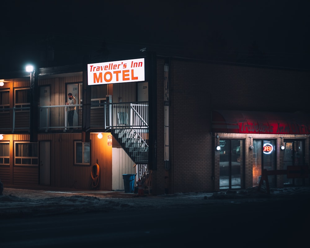 a motel at night with a car parked in front of it