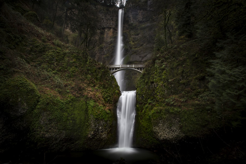 a large waterfall with a bridge over it