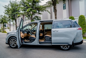 a silver minivan parked on the side of the road
