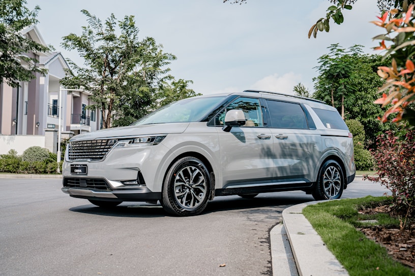 A shiny 7-passenger van parked in front of a leafy suburban street in Cobb County.